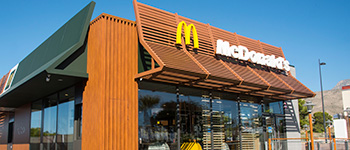 budova Mcdonalds s modrou oblohou a logom na čele budovy