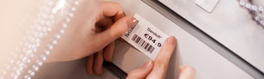 Shelf-edge label printed on Brother label printer being applied to edge of shelf